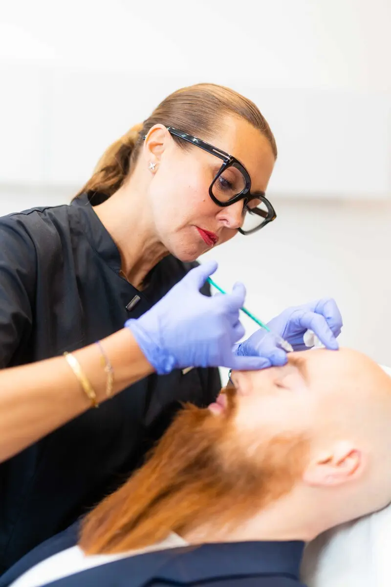 Mann mit orangenen Bart bei einer Botox Zornesfalten Behandlung